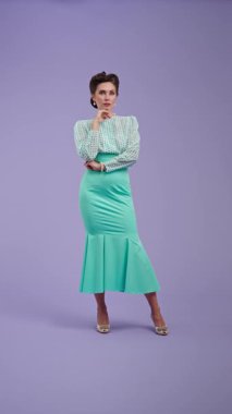 Klasik kıyafetli, çekici saç stili olan genç bir kadın mor stüdyo geçmişinde poz veriyor. Retro tarzı düşünen güzel bir aktris, sonra güzel bir fikir geliyor. Güzellik ve eski tarz konsept