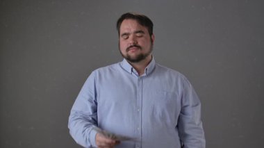 Havada yüzen banknotlarla güvenle duran bir adam refah ve başarı manzarası sergiliyor. Yavaş çekim