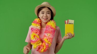 Çiçekli genç kız mor bavulun yanında duruyor ve elinde pasaport ve uçak biletleri var. Krom anahtar yeşil ekran yeşil ekran stüdyo arka plan modelinde izole edilmiş. Yavaş çekim