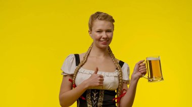 Bavyera kıyafetli neşeli bir kadın elinde parlak sarı bir arka planda bira bardağı tutuyor. Gülümsüyor ve başparmak işareti yapıyor, neşeli ve hayat dolu bir atmosferi simgeliyor..