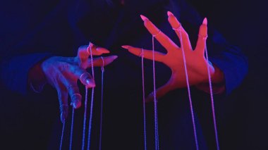 Güç ve kontrol temalarını öne süren, canlı ışıklandırmayla aydınlatılan, dizileri kontrol eden ellerin büyüleyici bir görüntüsü..