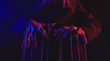 Dizgileri kontrol eden elleri tasvir eden kavramsal resim, dramatik bir mor ve kırmızı ışıklandırma arka planına karşı ayarlanır.