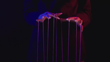 Manipülasyonu resmeden dramatik ışıklandırmada eller ve teller kullanılarak kontrol ve nüfuzun sembolü. Yavaş çekim