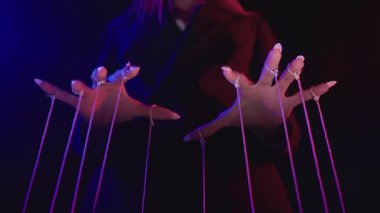 Mor renkli loş bir odada ipleri manipüle eden bir kişi gizem ve kontrol taşıyor. Yavaş çekim