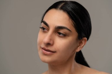 Sakin bir ifadeyle doğal güzelliği ve yumuşak ışıklandırmayı sergileyen bir kadının portresi..