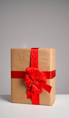 Zarif bir şekilde kahverengi kağıda sarılmış kırmızı bir kurdele ve fiyonk, özel durumlar için mükemmel..