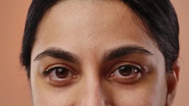 İnsan gözlerine ve doğal kaşlara odaklanan, dokuyu ve rengi vurgulayan detaylı bir yakın plan görüntüsü. Yavaş çekim