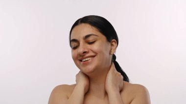 Gözleri kapalı gülümseyen bir kadının huzurlu bir görüntüsü. Rahatlama ve sükunet anı yakalıyor..