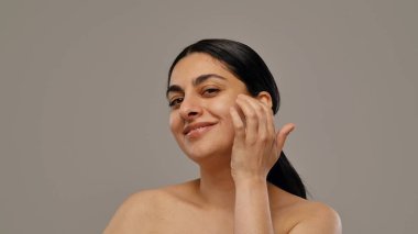 Kendine güvenen bir kadın, temiz, sağlıklı tenine dokunurken özgüvenini ve doğal güzelliğini yansıtır..