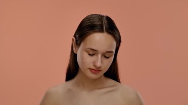 Bir kadın yüzüne serum uygulamak için bir damlatıcı kullanır. Cilt rutininde güzellik ve sağlığa vurgu yapılır, hidrasyona odaklanılır. Yavaş çekim