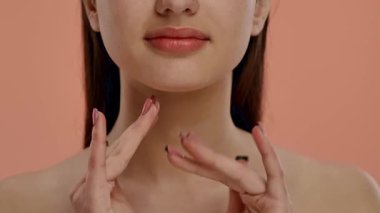 Resim, yüzüne nazikçe dokunan bir kadını tasvir ediyor. Tırnakları, cilt rengini tamamlayan şık bir Fransız manikür tasarımına sahip. Yavaş çekim