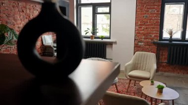 Lüks sandalyeleri, ahşap masaları, tuğla duvarları ve modern çalışma alanları için ofis olanakları olan rahat bir toplantı odası. Yavaş çekim.