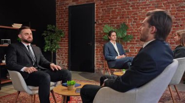 Bir grup profesyonel, modern ofis ortamında tuğladan bir arka planı olan bir iş görüşmesine giriştiler. Yavaş çekim.