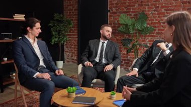 Modern bir ofis ortamında masanın etrafında oturan dört meslektaşı profesyonel bir iş toplantısındalar. Yavaş çekim.