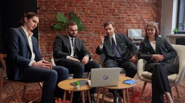 Resmi giyinmiş bir grup profesyonel, modern bir ofiste, duvarları tuğlalı bir ofiste toplantı yapıyorlar. Yavaş çekim.