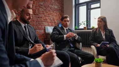 Modern ve şık bir ofis ortamında odaklanmış bir grup profesyonel iş adamı. Yavaş çekim.