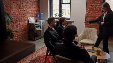 Modern ofis ortamında el sıkışma anlaşmasını sembolize eden, resmi giyinmiş bir grup iş adamı bir toplantıya katılıyor. Yavaş çekim.