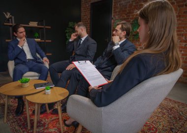 Bir grup profesyonel resmi bir toplantıda, dikkat ve ciddiyetle bir sözleşme belgesini tartışıyorlar..