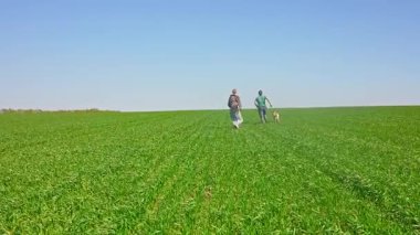 İki arkadaş yemyeşil bir alanda mutlu bir köpekle yürüyorlar. Açık mavi gökyüzü altında birbirlerine eşlik etmekten hoşlanırlar. Yavaş çekim