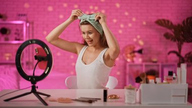 Bir içerik yaratıcısı, profesyonel ışıklandırma ve ekipmanlarla bir makyaj dersini filme alır, güzellik ürünleri sergiler..