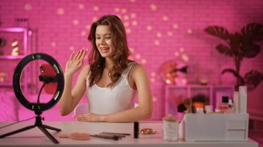 Bir içerik yaratıcısı, profesyonel ışıklandırma ve ekipmanlarla bir makyaj dersini filme alır, güzellik ürünleri sergiler..