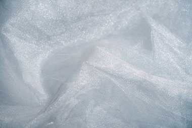 Bir fotoğraf, köpüklü su damlacıklarıyla süslenmiş karmaşık ağ kumaş desenlerini yakalar. Makro