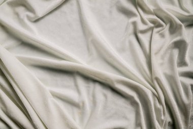 Yumuşak beyaz kumaş manzarası, nazik kıvrımlarını ve ince dokusunu sergiliyor, zarafet ve sadelik hissi yaratıyor. Makro