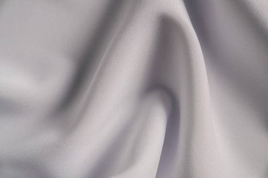 Yüksek çözünürlüklü bir görüntü beyaz bir kumaşın zarif kıvrımlarını ve dokusunu gösteriyor..