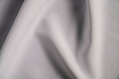 Yüksek çözünürlüklü bir görüntü beyaz bir kumaşın zarif kıvrımlarını ve dokusunu gösteriyor..