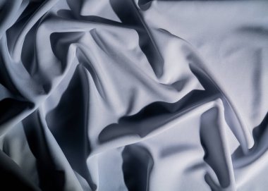 Zarif kıvrımlı pürüzsüz beyaz kumaş manzarası. Karmaşık bir ışık ve gölge deseni yaratıyor. Makro