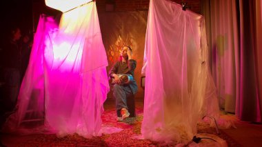 Sahne arkasında. Sanatsal bir ortamda canlı ve renkli ışıklarla aydınlatılmış bir insan eşsiz bir ruh hali yaratıyor..