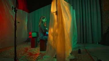 Sahne arkasında. Benzersiz ışıklandırma ve klasik televizyon unsurlarıyla donanımlı bir atmosfer yaratan modern bir sanat kurulumu..