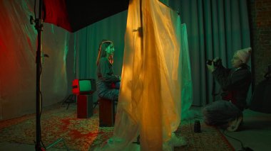 Sahne arkasında. Bir fotoğrafçı, arkaplanda canlı ışıklandırmayla eşsiz bir sahne yakalar ve sanatsal bir atmosfer yaratır..