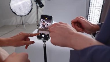 Sahne arkasında. Akıllı telefon kullanarak parfüm şişelerini fotoğraflamak için yaratıcı bir düzenek. Zarif ürün imgeleri sergiliyor..