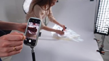 Sahne arkasında. Bir cep telefonu yaratıcı ışık efektleriyle ürün fotoğrafçılığını yakalar. Kurulum basit ve etkili..