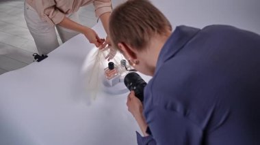 Sahne arkasında. Bir fotoğrafçı aksesuar düzenlerken kamera kullanarak bir ürünü yakalar. Yaratıcılığa ve detaylara odaklan.