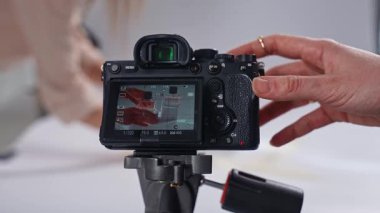 Sahne arkasında. Resim, bir tripodun üzerinde bir ürünü profesyonel bir stüdyoda yakalayan dijital bir kamera tasvir ediyor..