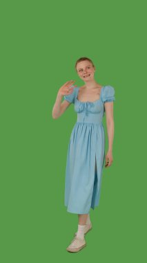 Mavi elbiseli biri yeşil ekranda yürüyor, kroma anahtarı. Yarım dönüş görünümü