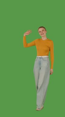 Sarı kazaklı ve geniş paçalı kotlu biri yeşil ekranda yürüyor, kroma anahtarlı. Yarım dönüş görünümü