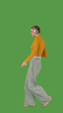 Kulaklık takan bir kişi yeşil ekranda dans ediyor ya da müzikten zevk alıyor, kroma tuşuyla. Yan görünüm