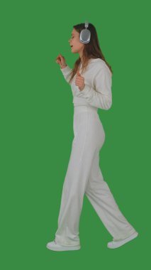 Kulaklık takan bir kişi yeşil ekranda dans ediyor ya da müzikten zevk alıyor, kroma tuşuyla. Yan görünüm