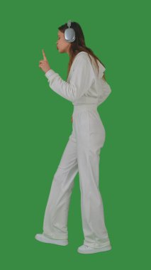 Kulaklık takan bir kişi yeşil ekranda dans ediyor ya da müzikten zevk alıyor, kroma tuşuyla. Yan görünüm