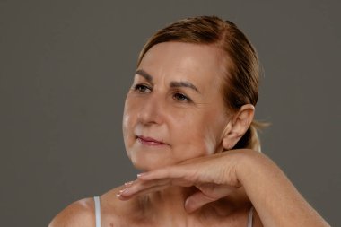 Doğal bir ifadeyle olgun bir kadının portresi. Kendine güvenen ve sakin tavrını sergiliyor..