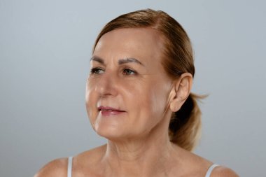 Doğal bir ifadeyle olgun bir kadının portresi. Kendine güvenen ve sakin tavrını sergiliyor..