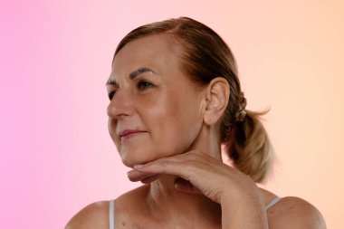 Olgun kadınlar, düşünceli bir yüz ifadesi. Elleri nazikçe yüzünde dinleniyor..