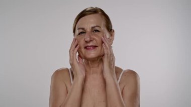 Olgun kadınların düşünceli ifadeleri. Elleri nazikçe yüzünde dinleniyor. Yavaş çekim