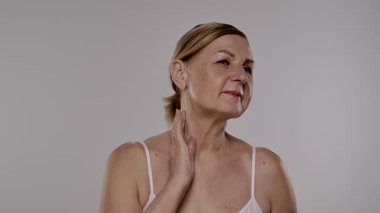 Neşeli bir kadın yaşlanmayı önleyici krem sürerek cilt bakımını besleyici su ve tazelikle arttırır. Yavaş çekim