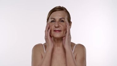 Olgun kadınların düşünceli ifadeleri. Elleri nazikçe yüzünde dinleniyor. Yavaş çekim