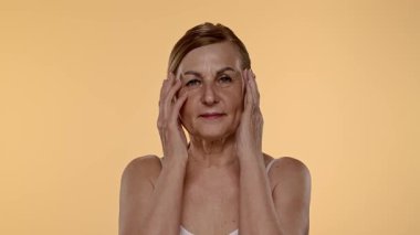 Olgun kadınların düşünceli ifadeleri. Elleri nazikçe yüzünde dinleniyor. Yavaş çekim