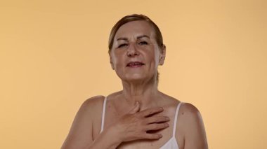 Olgun kadınların düşünceli ifadeleri. Elleri nazikçe yüzünde dinleniyor. Yavaş çekim